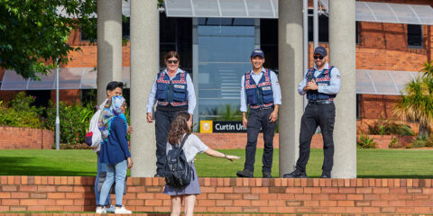 3 Safer Community guards laughing with 3 students