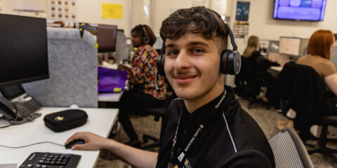 Man with headphones sitting on a computer