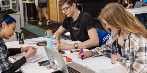 a group of students gathered at a table, highlighting information