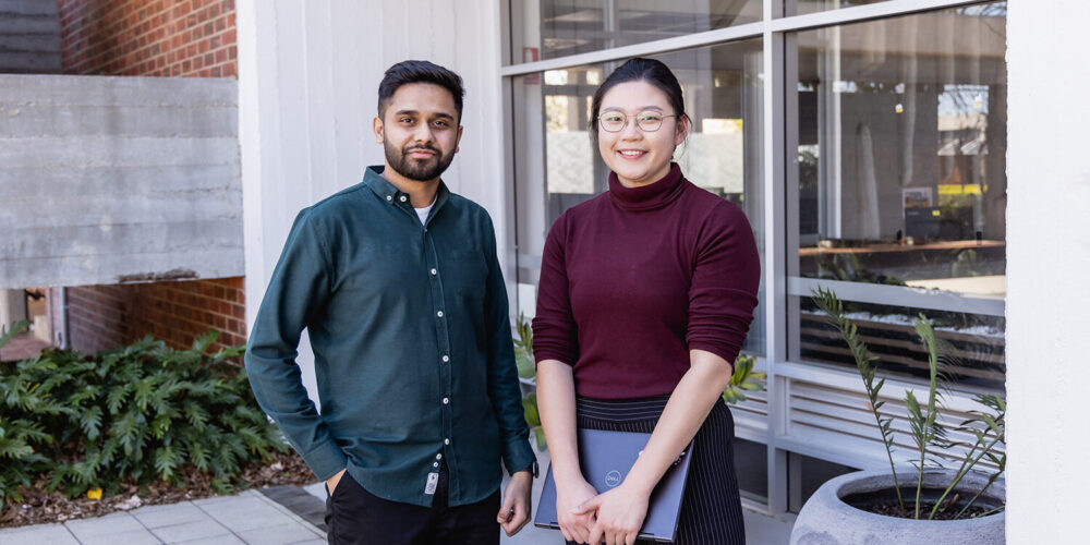 a male and female student standing outside and smiling