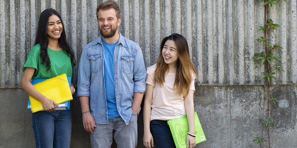 Three people standing in front of concrete