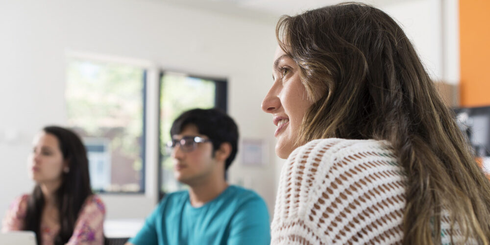 Three students looking at something inside a class