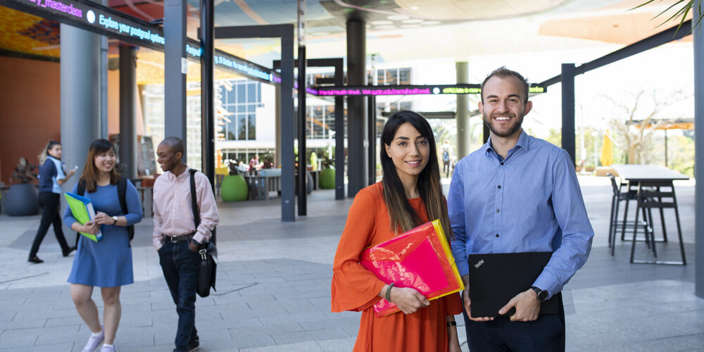 2 students in the business area, smiling