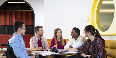 a group of people seated around a table and talking to each other