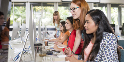 female students in a classroom working on computers