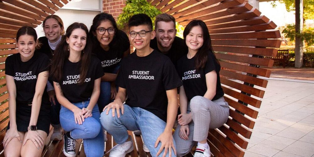 Group of students posing together in a wooden structure