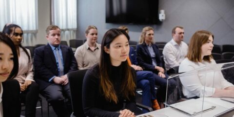 Group of people sitting in a room in rows