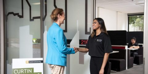 Two people shaking hands in front of the tax clinic