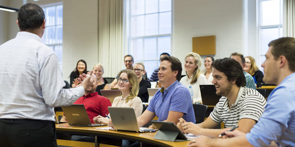 students in classroom laughing with lecturer