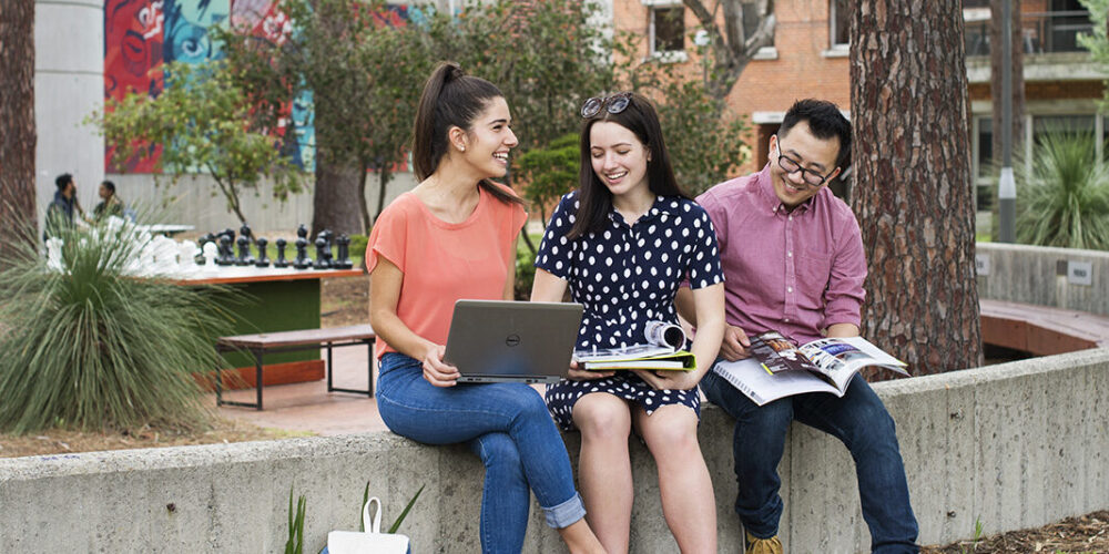 3 students sitting on a bench