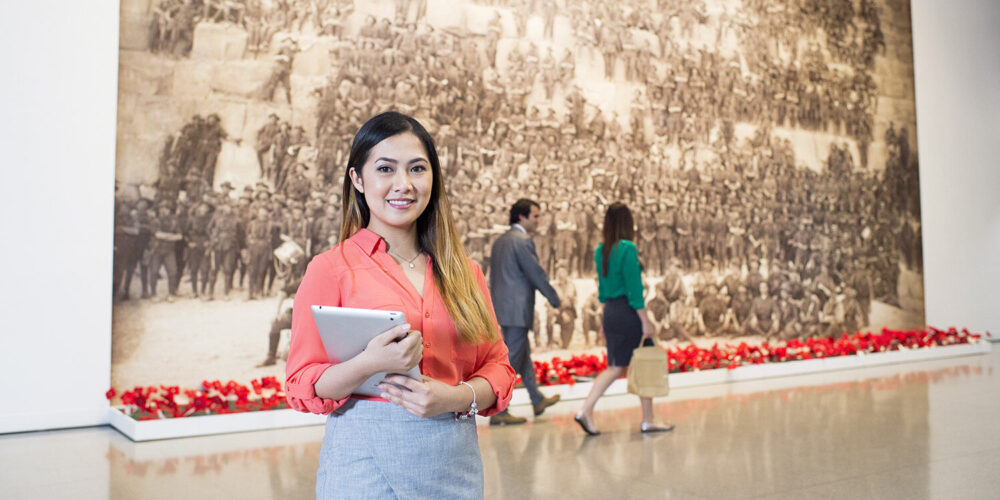 female student holding an ipad and smiling