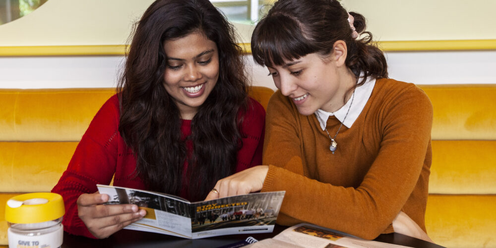 2 students reading a pamphlet