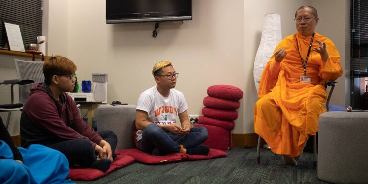 People listening to a Buddhist monk preach